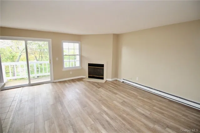 an empty room with wooden floor and fireplace
