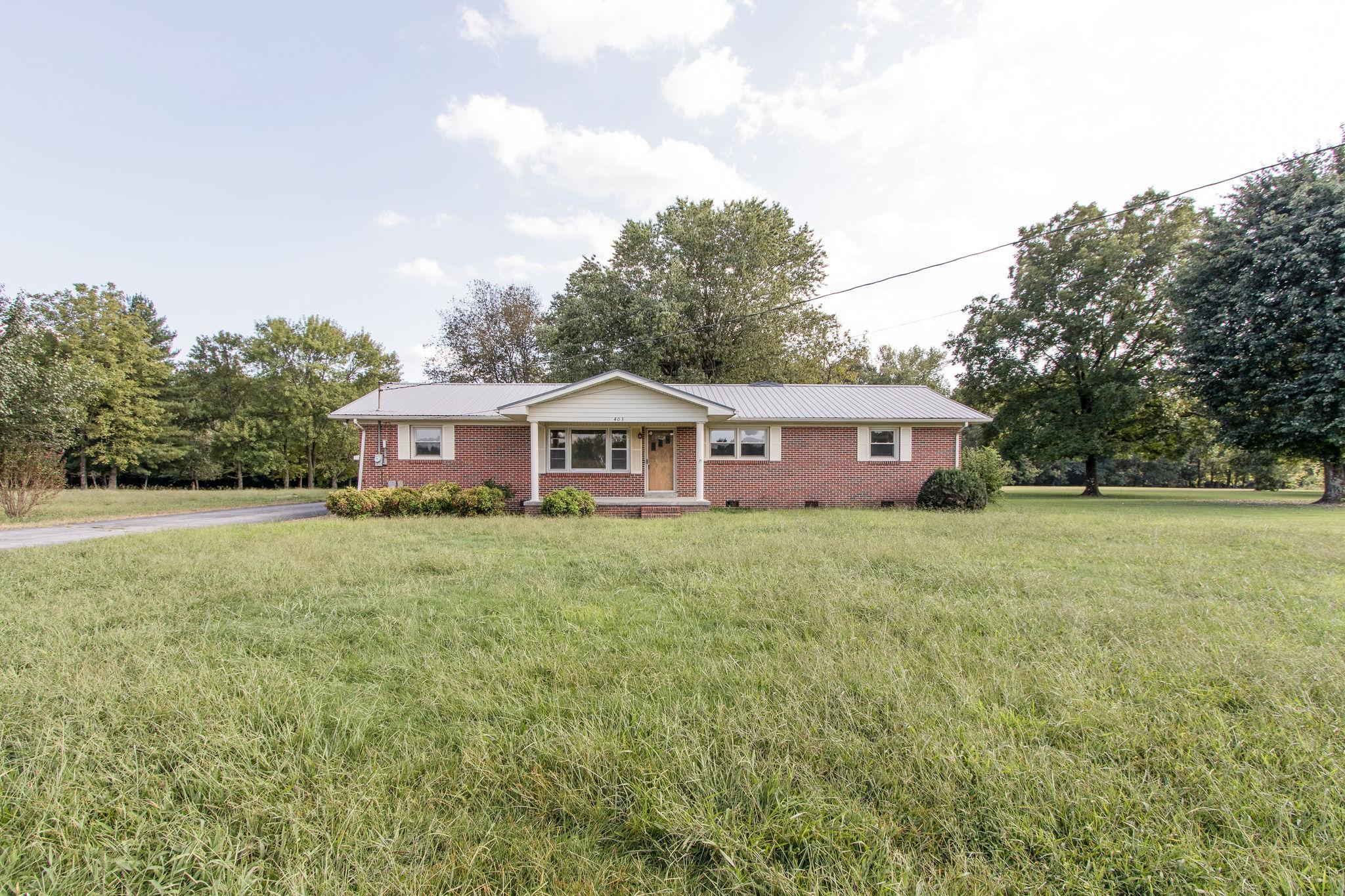 a front view of a house with a yard and trees