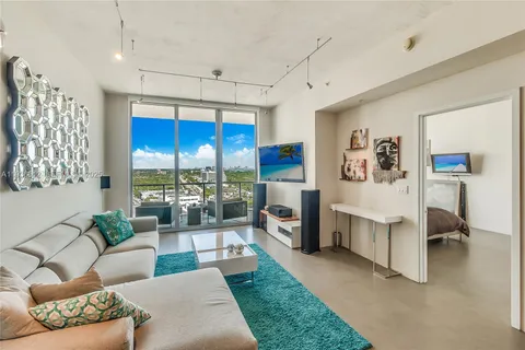 a living room with furniture pool table and a large window