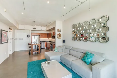 a living room with furniture and a dining table with rug kitchen