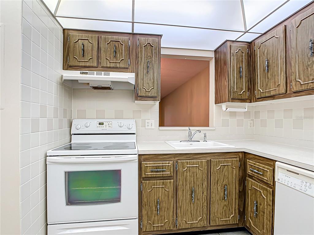 11485 Oakhurst Road, Unit 107 Largo, FL 33774 - Photo 14 of 60 a kitchen with stainless steel appliances granite countertop a sink and cabinets