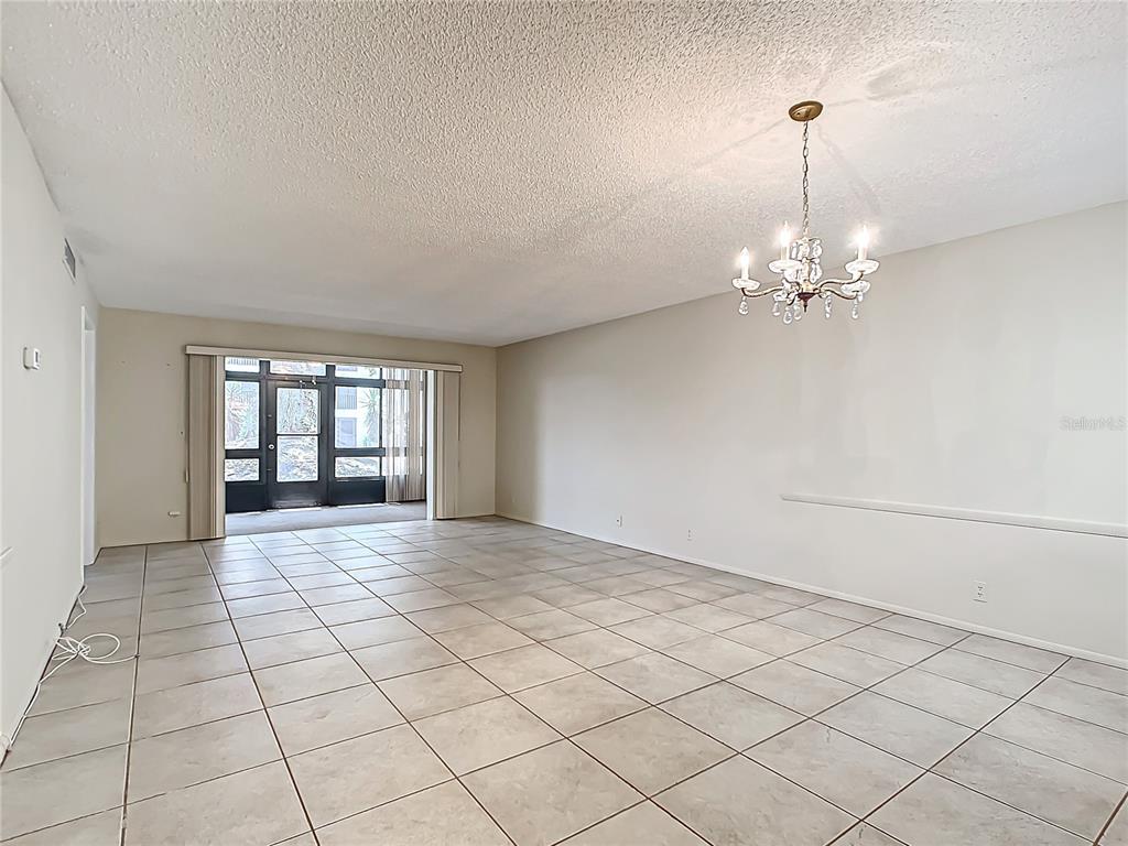 11485 Oakhurst Road, Unit 107 Largo, FL 33774 - Photo 16 of 60 a view of an empty room with window and chandelier