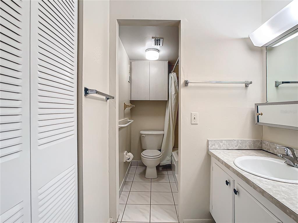 11485 Oakhurst Road, Unit 107 Largo, FL 33774 - Photo 34 of 60 a bathroom with a granite countertop toilet and a sink