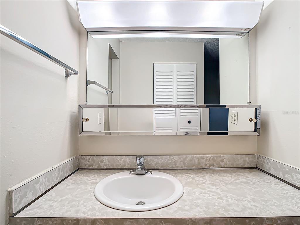 11485 Oakhurst Road, Unit 107 Largo, FL 33774 - Photo 35 of 60 a bathroom with a sink and a mirror