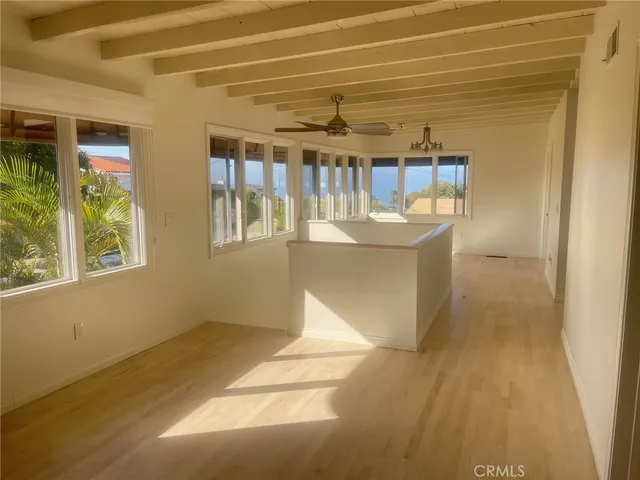 a view of a room with wooden floor and windows