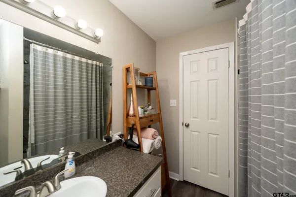 a bathroom with a granite countertop sink mirror and toilet