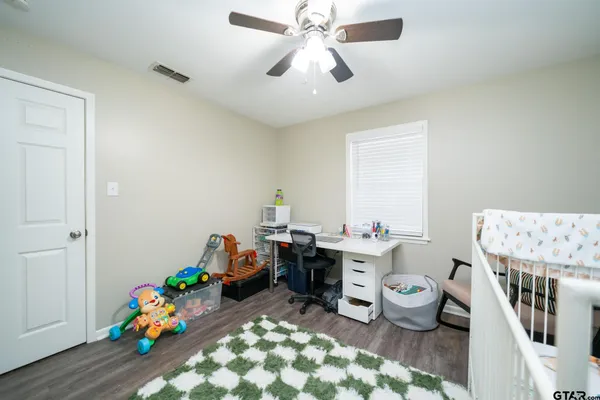 a living room with furniture a baby crib and a chandelier