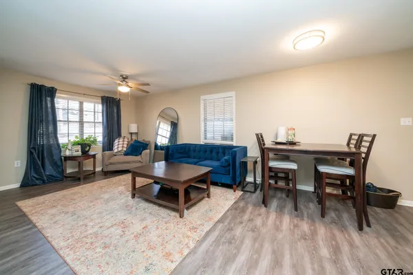 a living room with furniture a rug and a table