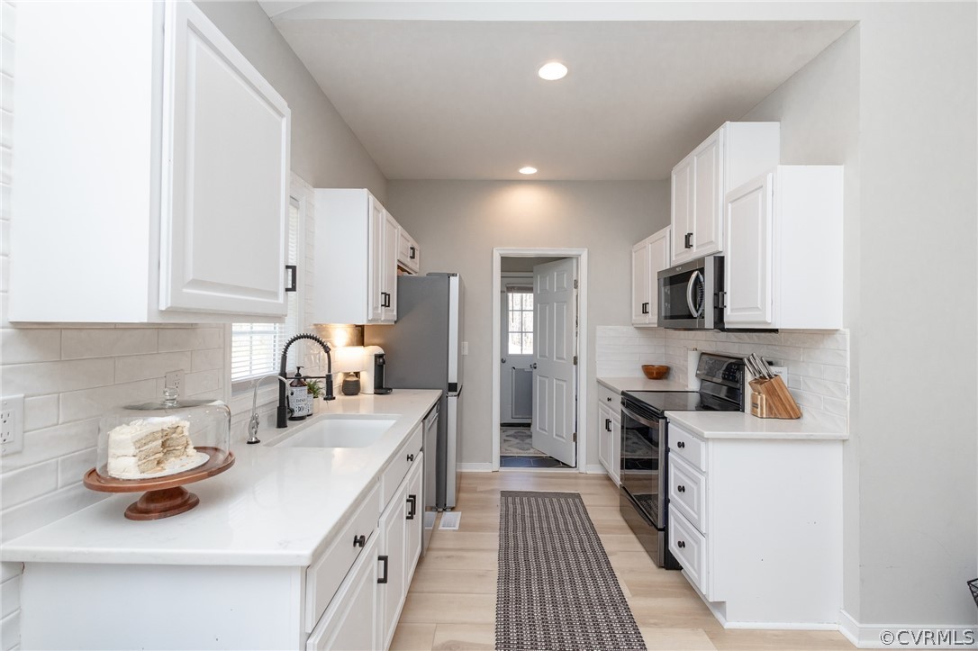 2406 Emanuel Church Road Powhatan, VA 23139 - Photo 19 of 50 a kitchen with stainless steel appliances a sink stove and cabinets