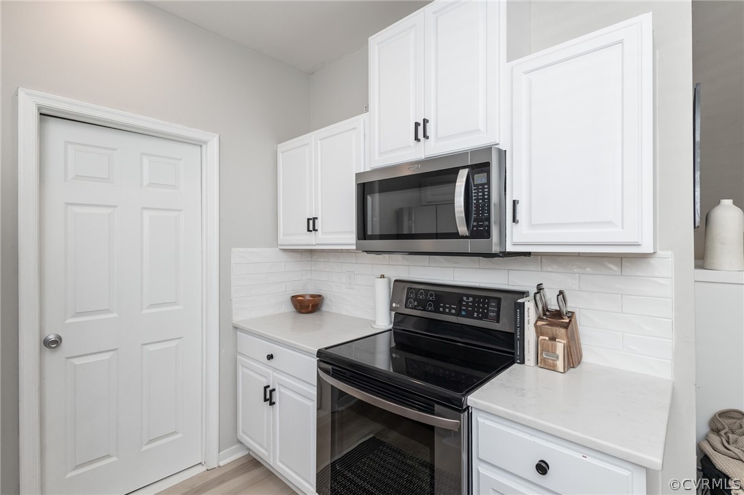 2406 Emanuel Church Road Powhatan, VA 23139 - Photo 21 of 50 a kitchen with white cabinets and stainless steel appliances