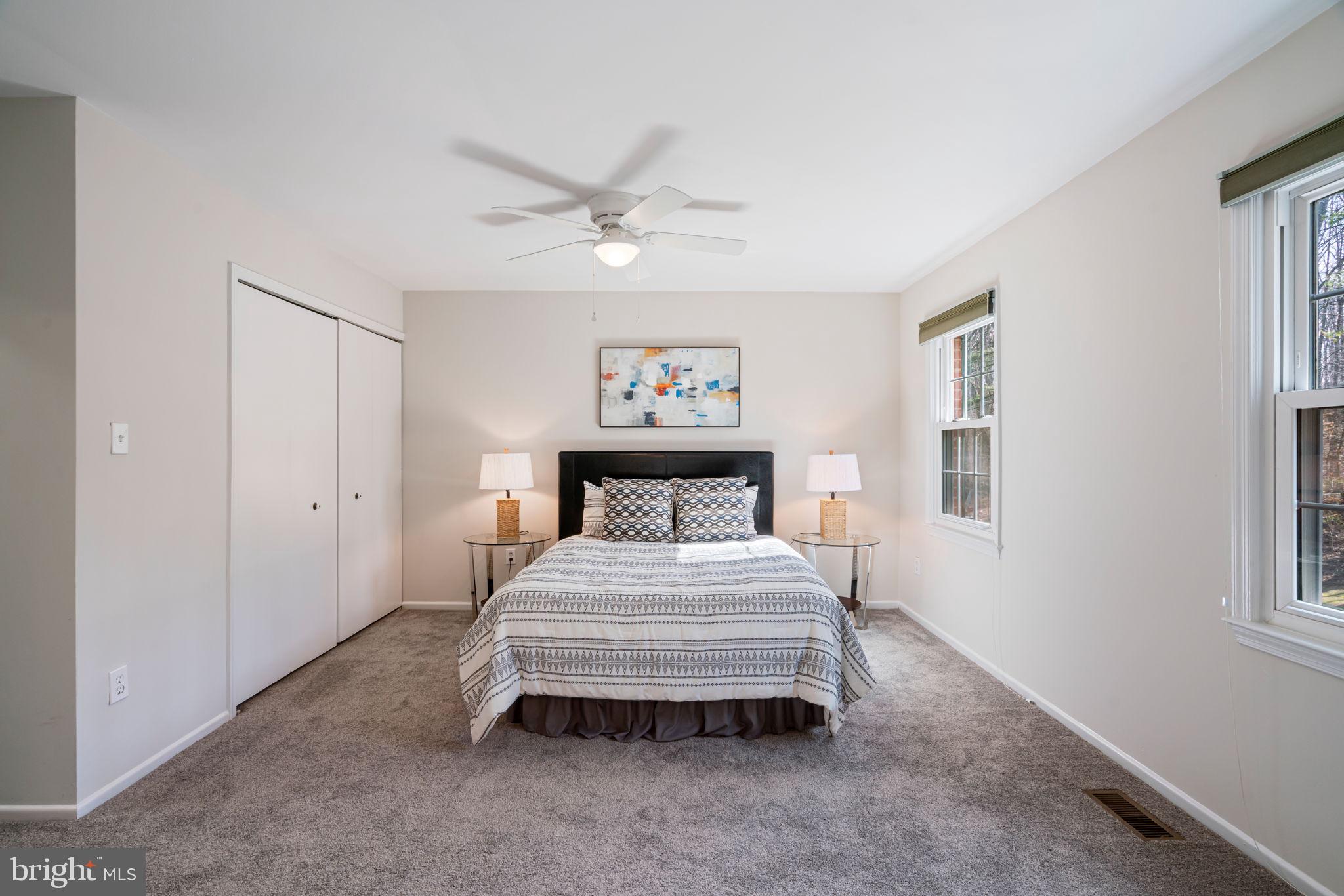 5702 Kirkham Court Springfield, VA 22151 - Photo 17 of 36 a spacious bedroom with a bed and a chandelier
