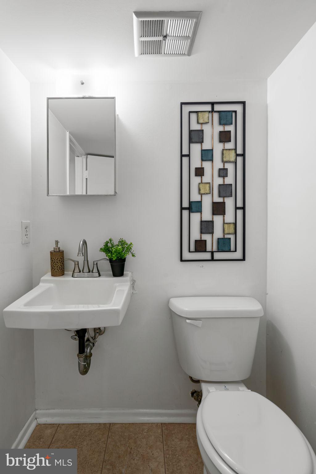 5702 Kirkham Court Springfield, VA 22151 - Photo 30 of 36 a bathroom with a toilet a sink and mirror