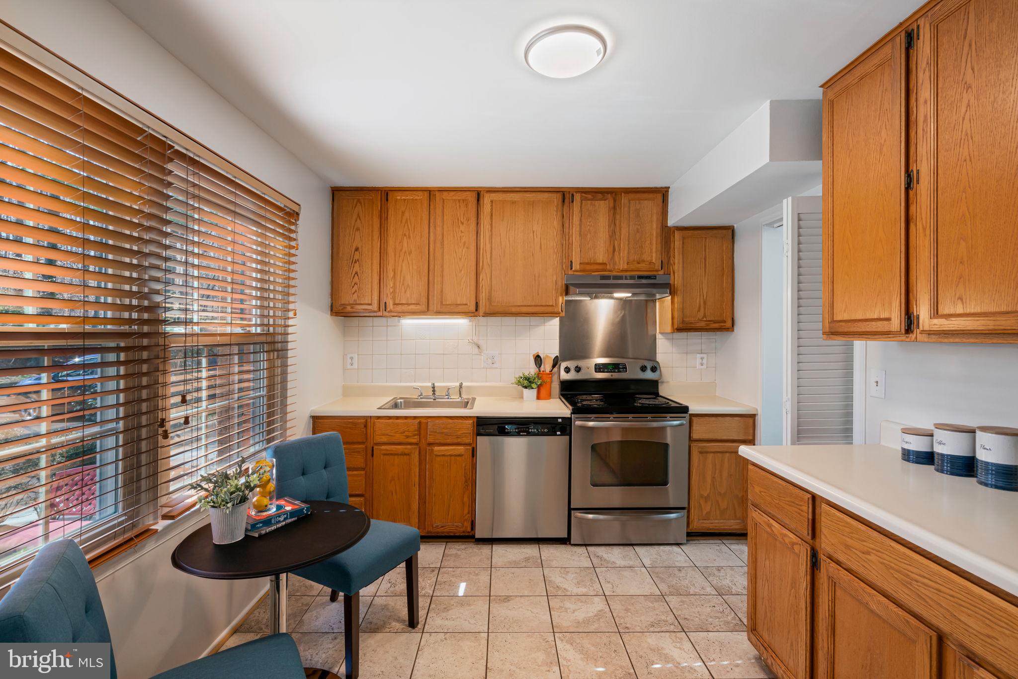 5702 Kirkham Court Springfield, VA 22151 - Photo 5 of 36 a kitchen with stainless steel appliances a stove a sink a microwave a refrigerator and cabinets