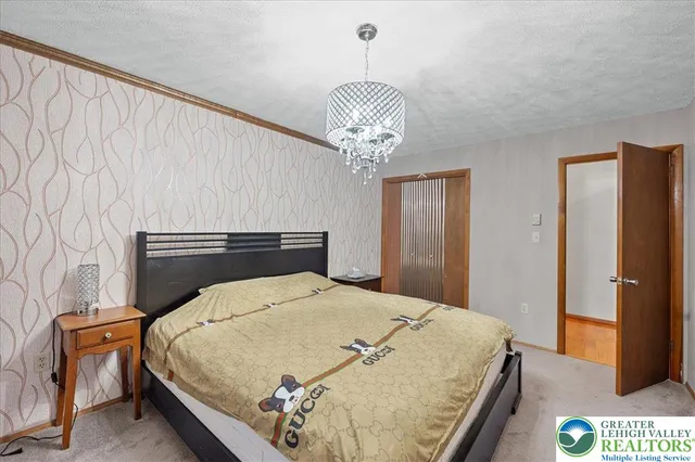 a bedroom with a bed and a chandelier