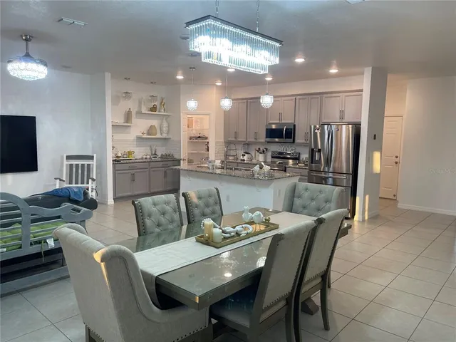 a dining room with furniture a large window and kitchen view