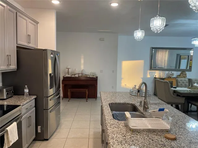 a kitchen with stainless steel appliances granite countertop a sink refrigerator and cabinets