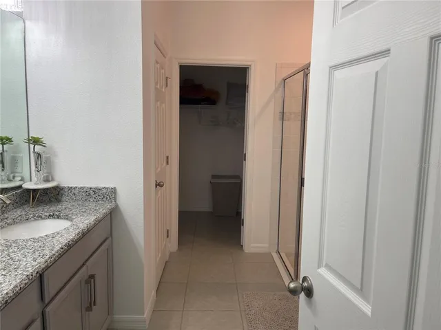 a en suite bathroom with a granite countertop sink and a mirror