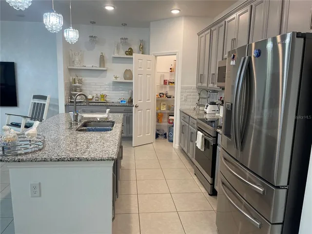 a kitchen with stainless steel appliances granite countertop a refrigerator and a sink