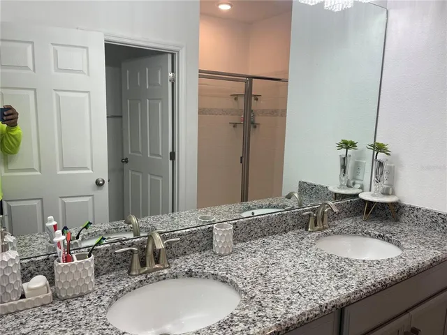 a bathroom with a granite countertop sink and a mirror