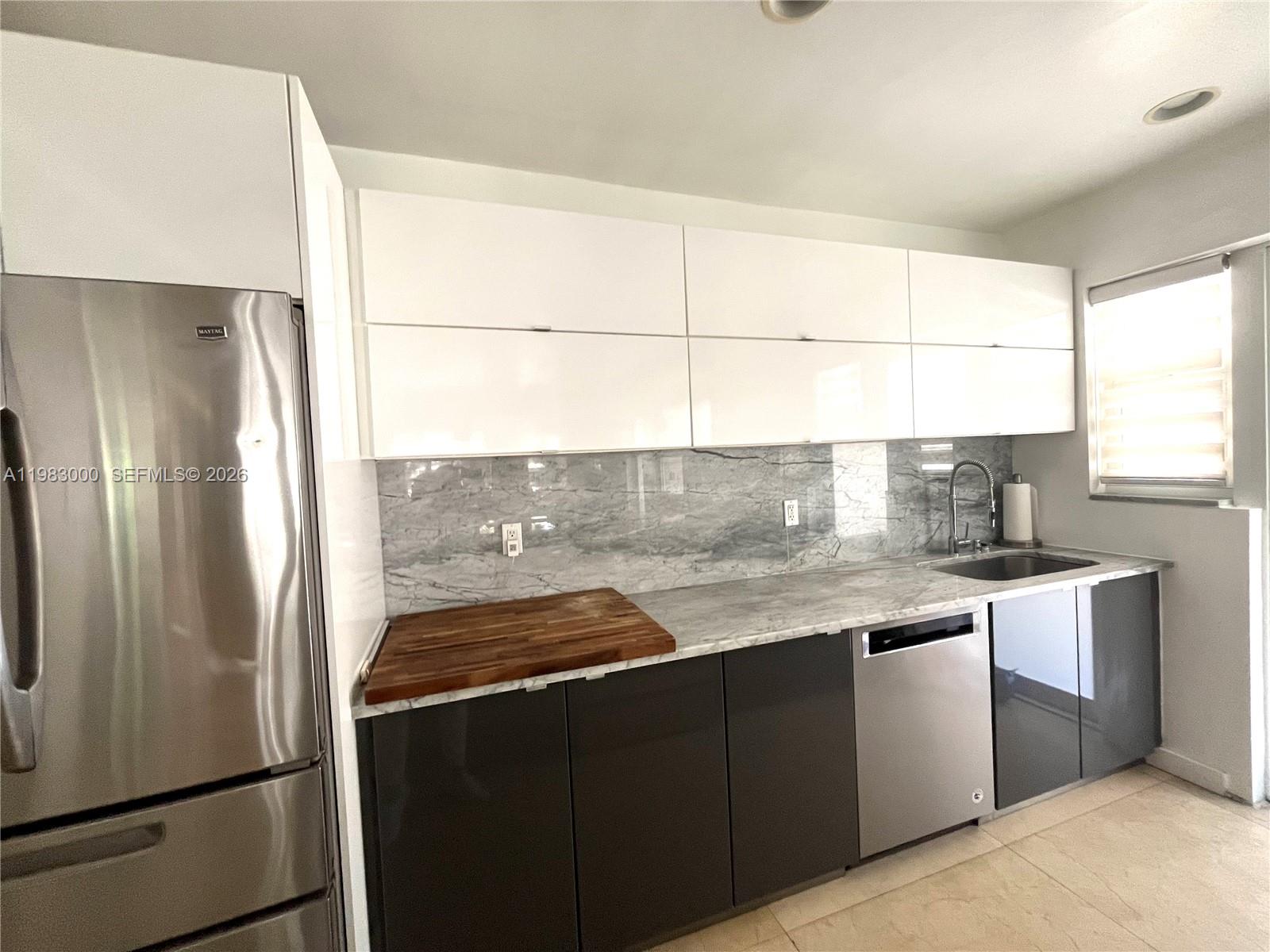 10190 Collins Avenue, Unit 106 Bal Harbour, FL 33154 - Photo 11 of 21 a kitchen with granite countertop a refrigerator and a sink