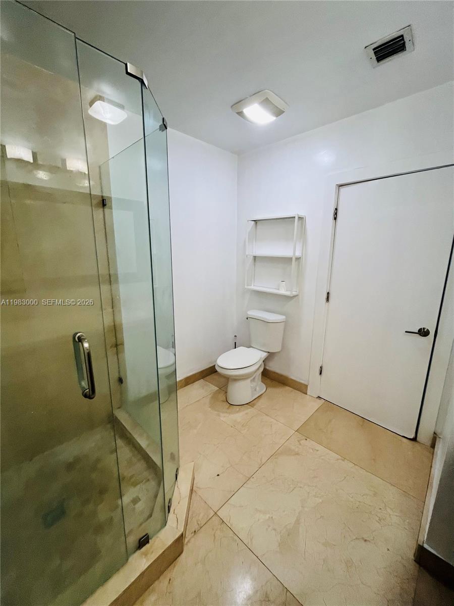 10190 Collins Avenue, Unit 106 Bal Harbour, FL 33154 - Photo 16 of 21 a bathroom with a shower and a toilet