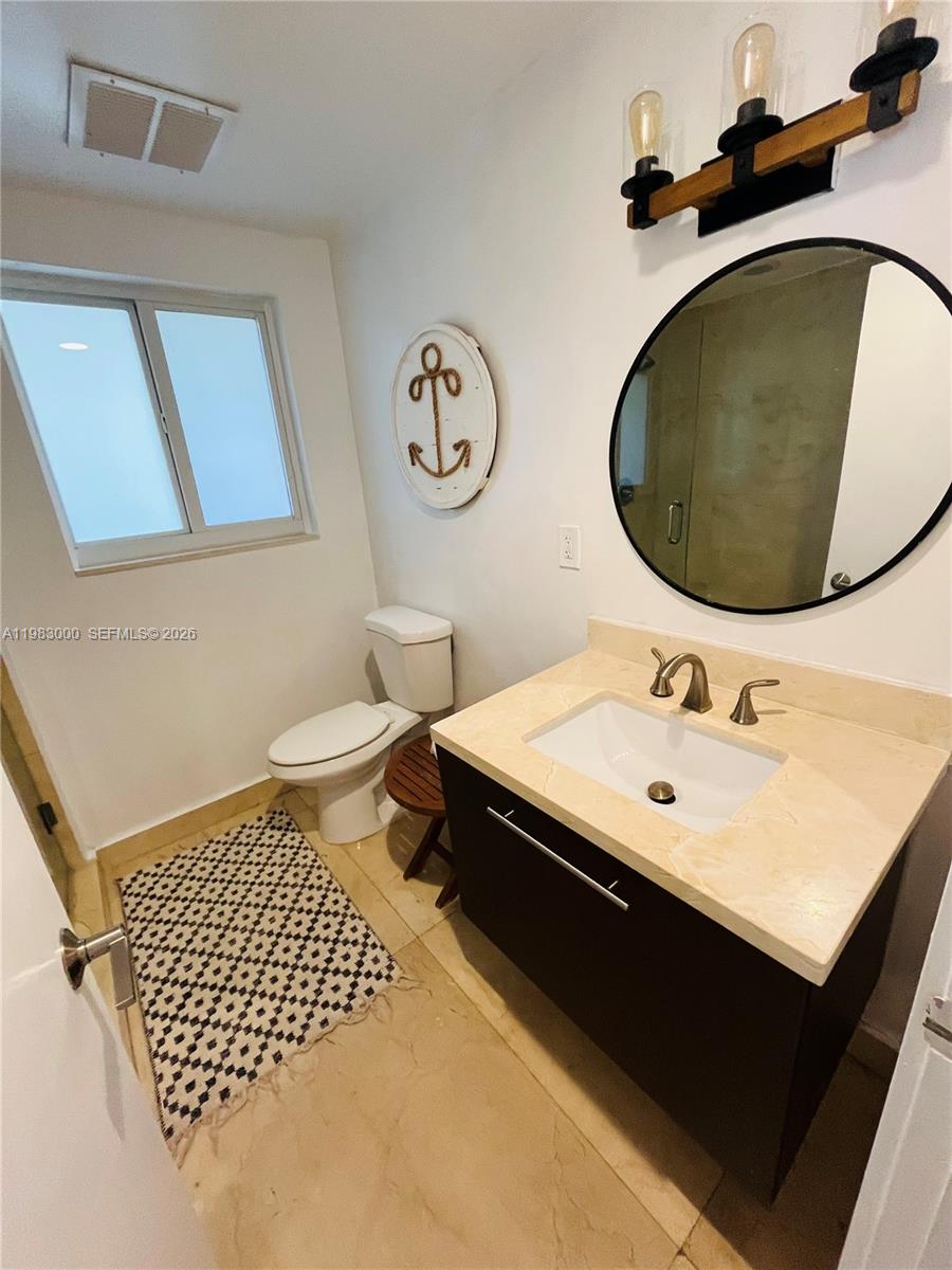 10190 Collins Avenue, Unit 106 Bal Harbour, FL 33154 - Photo 19 of 21 a bathroom with a sink and a mirror