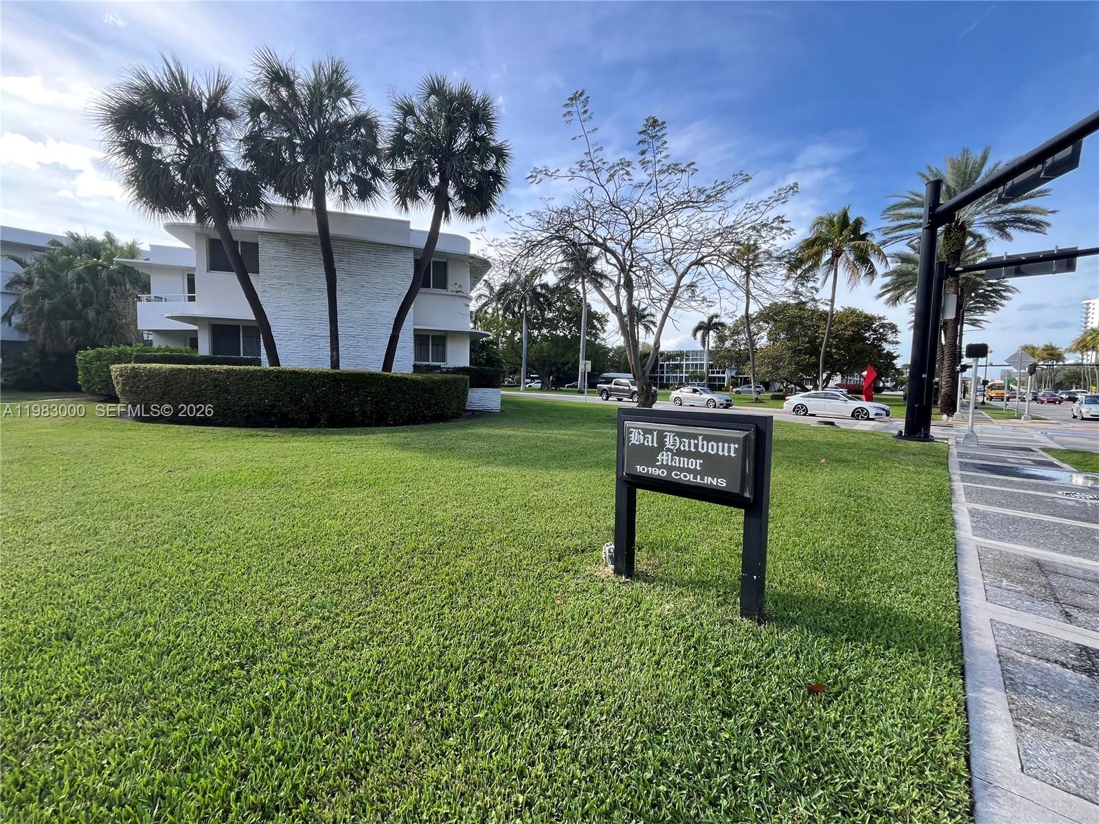 10190 Collins Avenue, Unit 106 Bal Harbour, FL 33154 - Photo 2 of 21 a bench sitting in the grass near a tree