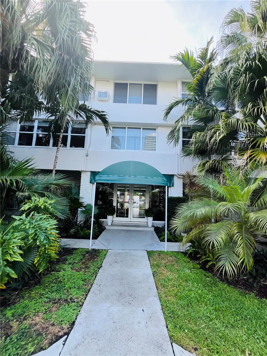 10190 Collins Avenue, Unit 106 Bal Harbour, FL 33154 - Photo 4 of 21 a front view of a house with a yard and porch
