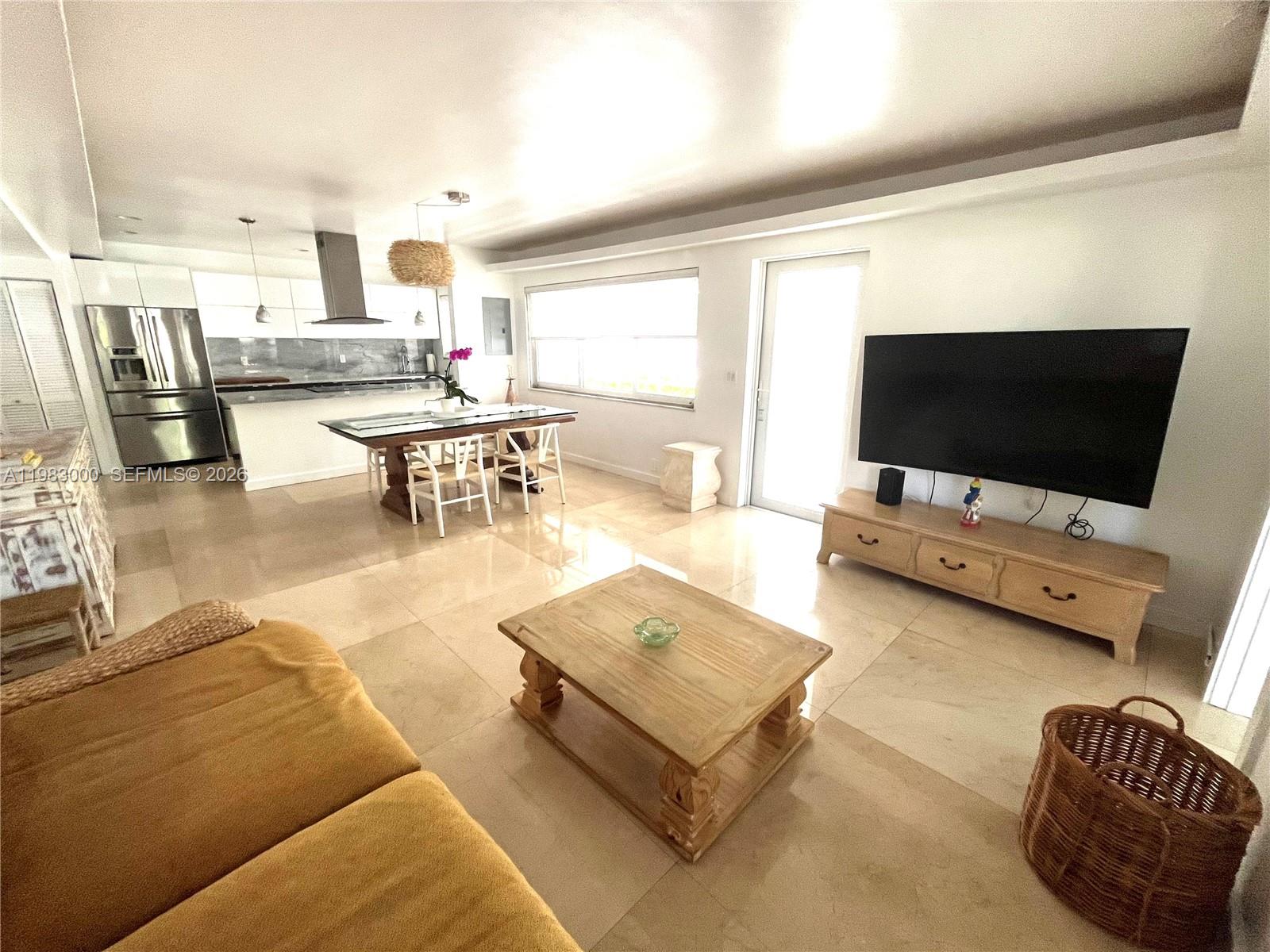 10190 Collins Avenue, Unit 106 Bal Harbour, FL 33154 - Photo 8 of 21 a living room with furniture and a flat screen tv