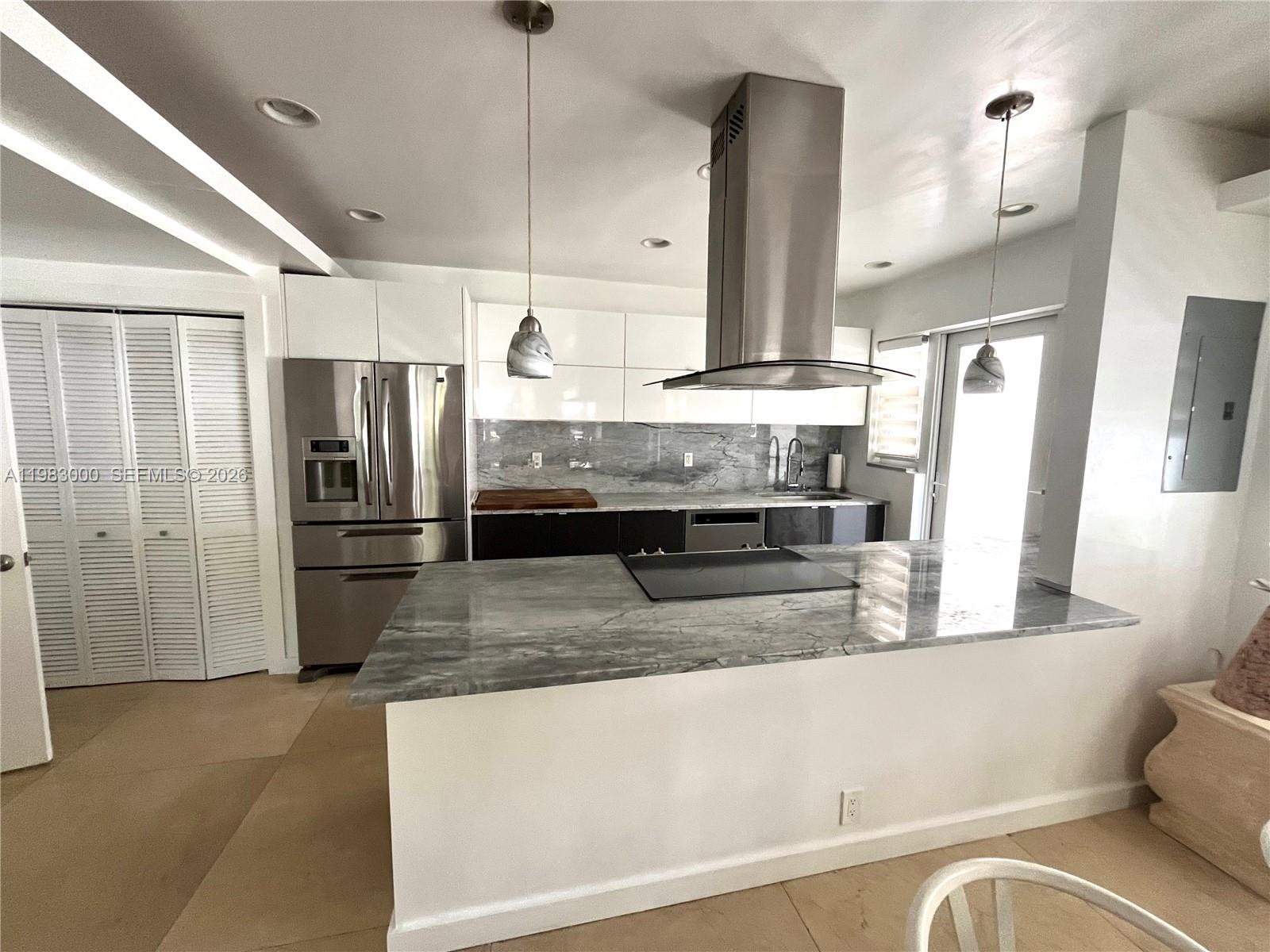 10190 Collins Avenue, Unit 106 Bal Harbour, FL 33154 - Photo 9 of 21 a view of a kitchen with stainless steel appliances granite countertop a refrigerator and a sink