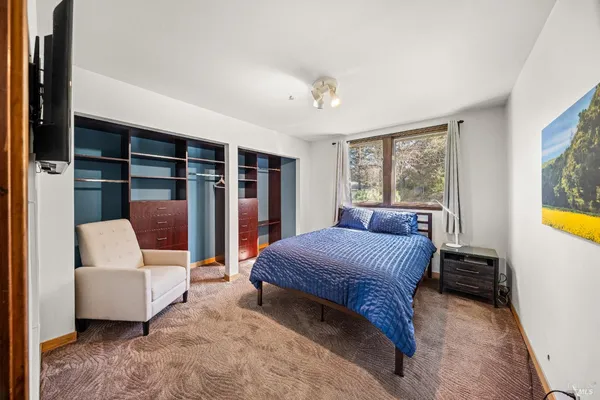 a bedroom with furniture and a large window
