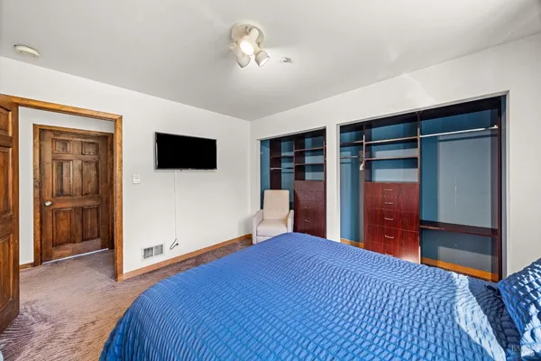 a bedroom with a large bed and a flat tv screen