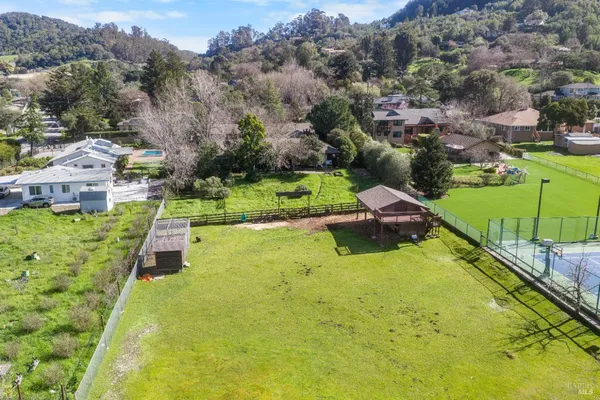 an aerial view of a house with a yard and lake view