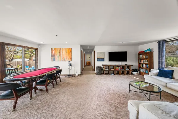 a living room with furniture a flat screen tv and a large window