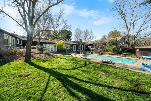 a view of a house with a yard patio and swimming pool
