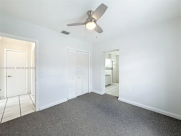 an empty room with fan and windows