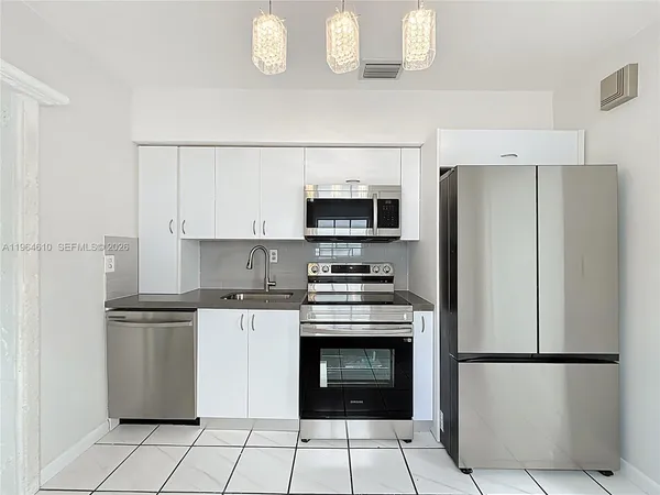 a white refrigerator freezer and a stove sitting inside of a kitchen