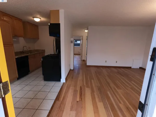 a kitchen with wooden floors and refrigerator