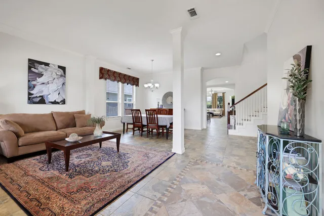a living room with furniture a dining table and a potted plant