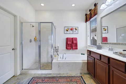 a bathroom with a tub a sink and a shower
