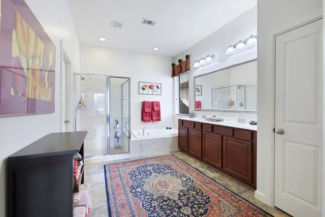 a spacious bathroom with a bathtub sink and mirror