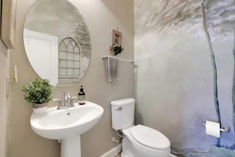 a bathroom with a sink toilet and mirror