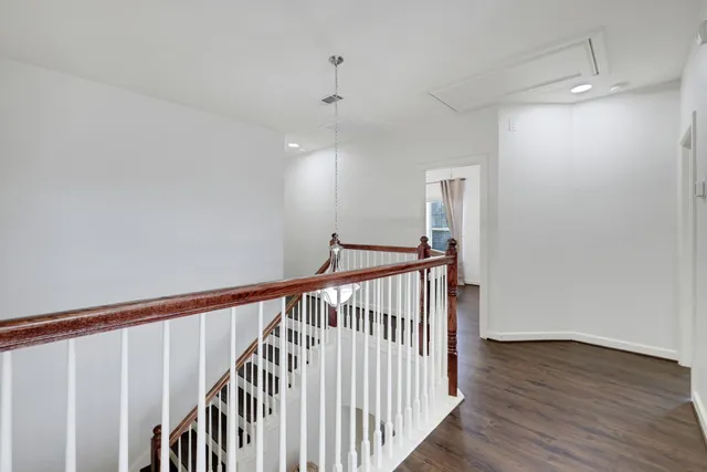 a view of staircase with railing and white walls