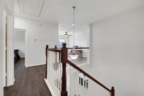 a view of a hallway with wooden floor and stairs