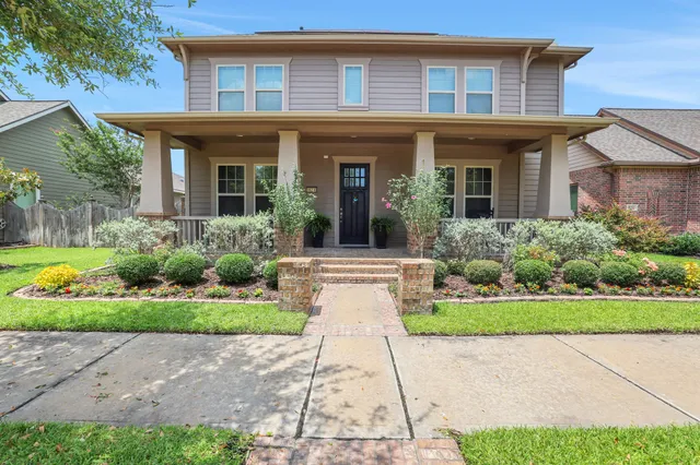 a front view of a house with a yard and potted plants