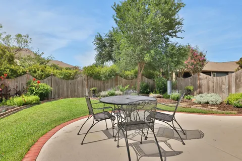 a view of a patio with a table and chairs and potted plants