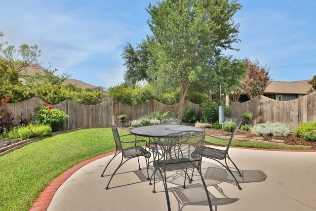 a view of a patio with a table and chairs and potted plants