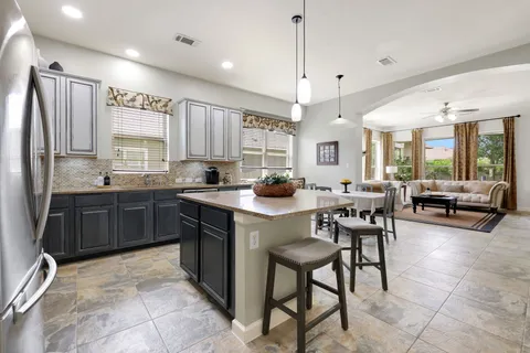 a kitchen with stainless steel appliances granite countertop a stove a sink a oven a dining table and chairs