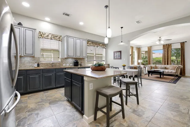 a kitchen with stainless steel appliances granite countertop a stove a sink a oven a dining table and chairs