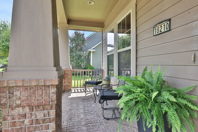 a balcony with chairs and with potted plants